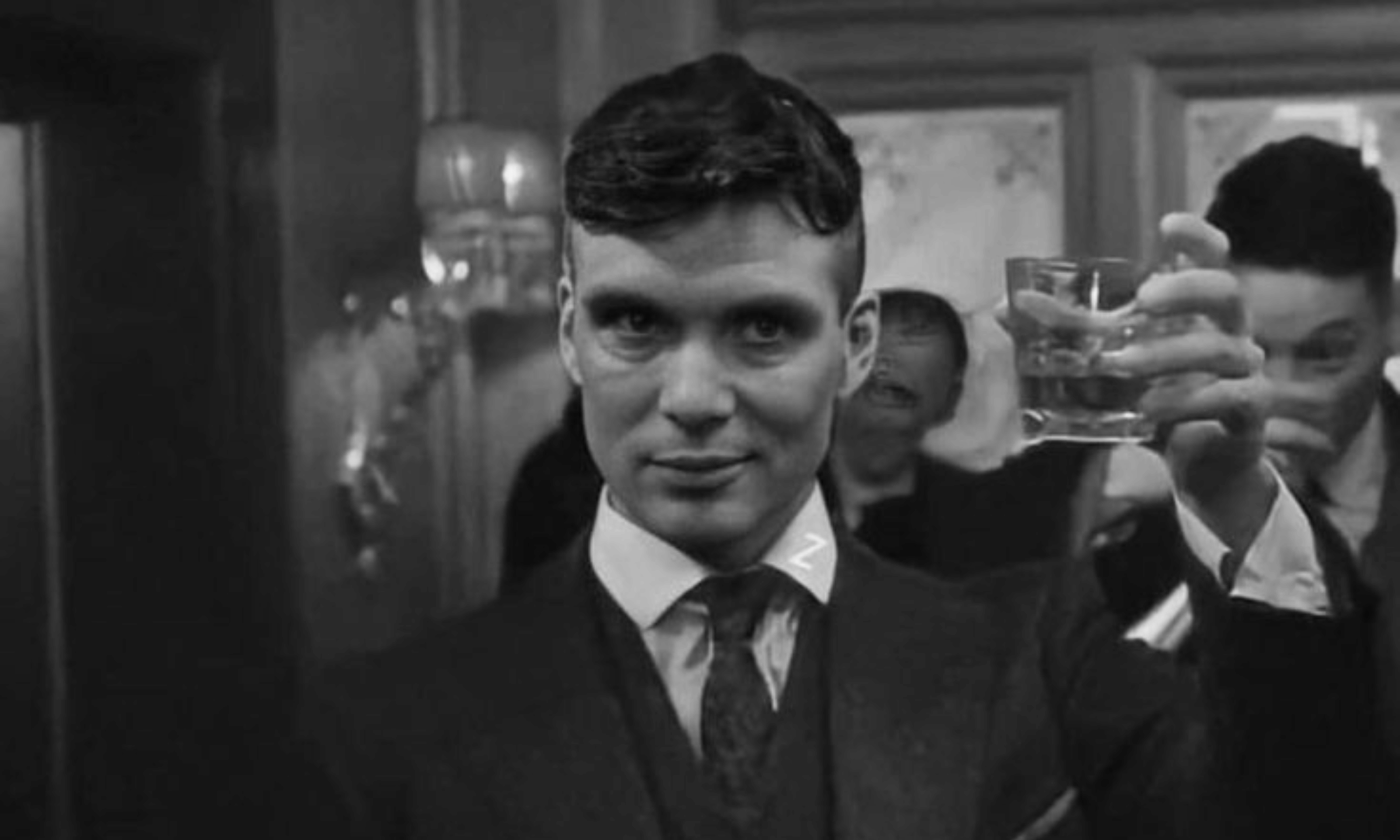 Black-and-white bar scene with raised glass crowded, performative energy.