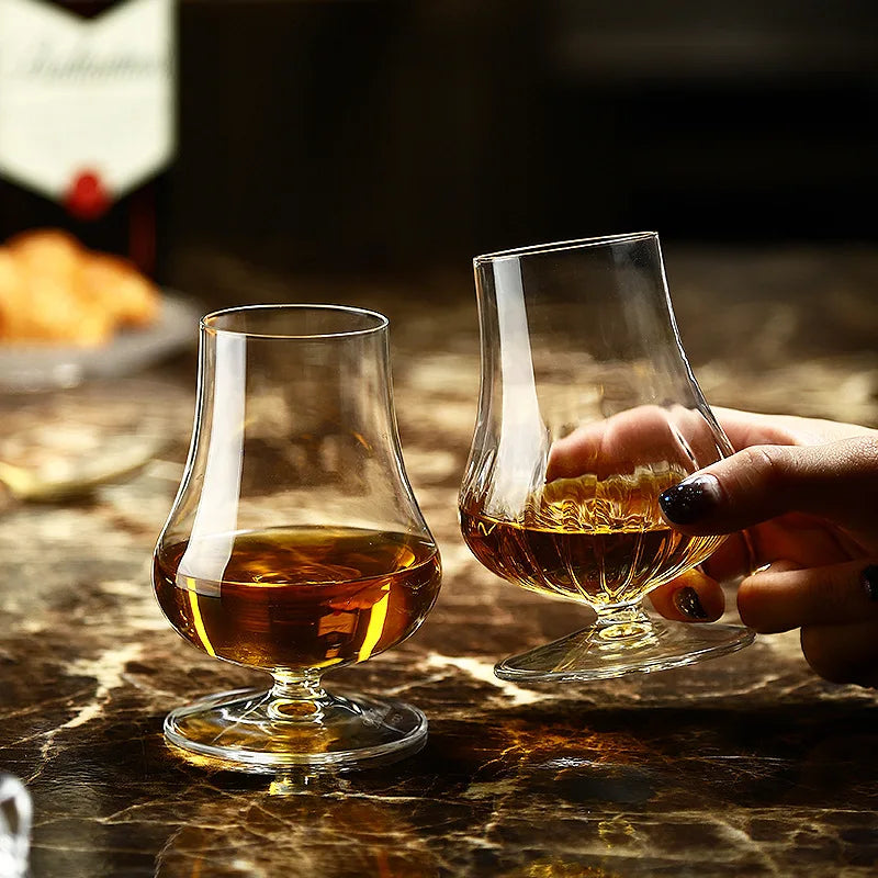 Heavy weighted base and wide foot of tulip nosing glass shown in hand