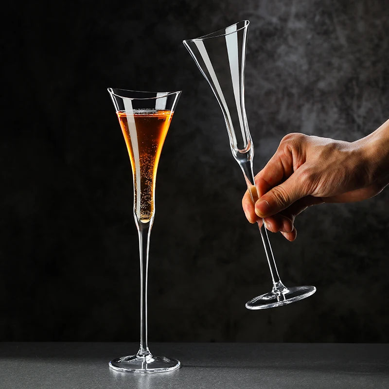 crystal tulip champagne glass with tall stem filled with sparkling wine on dark background