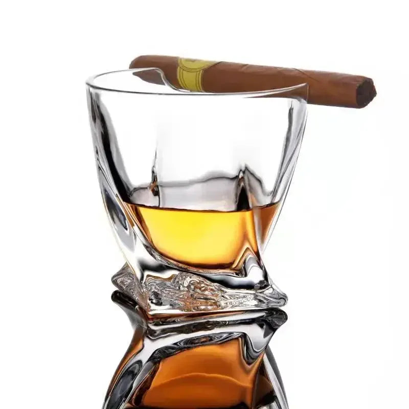 Hand holding whiskey and cigar glass during poker night
