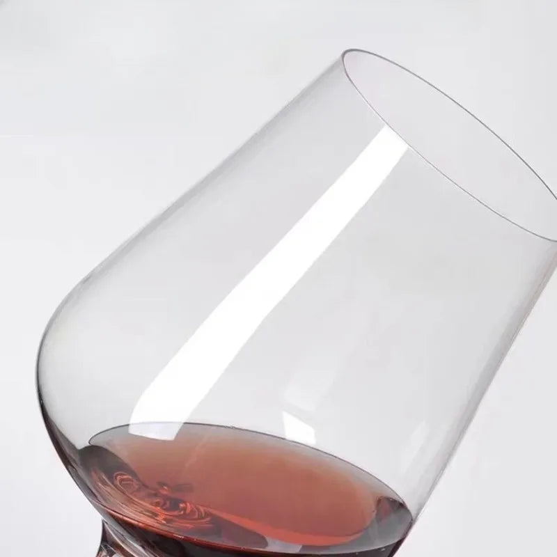balancing crystal wine glass lying sideways with red wine inside