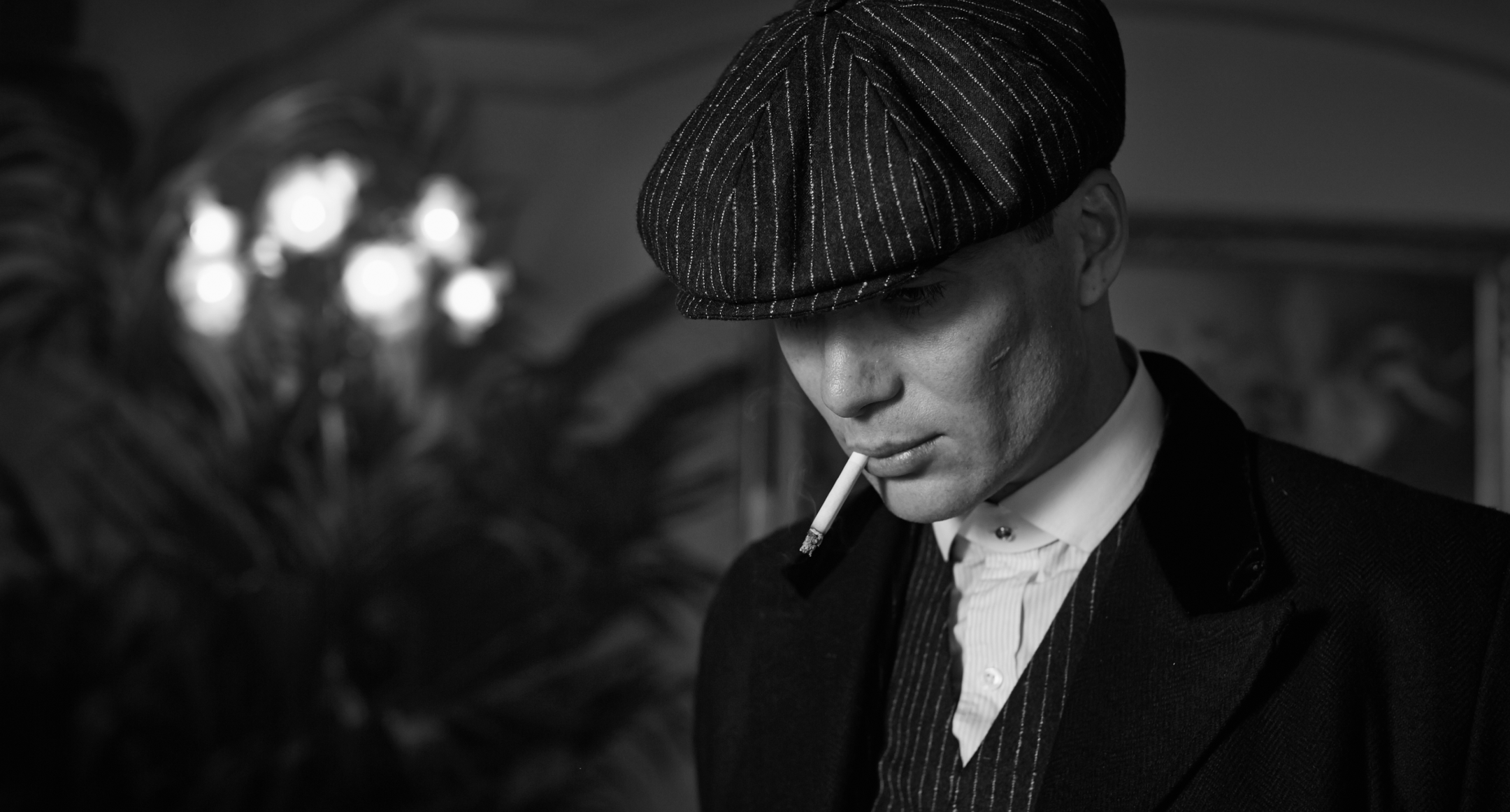 Tommy Shelby close-up in pinstripe cap and suit - quiet power, tailored heritage