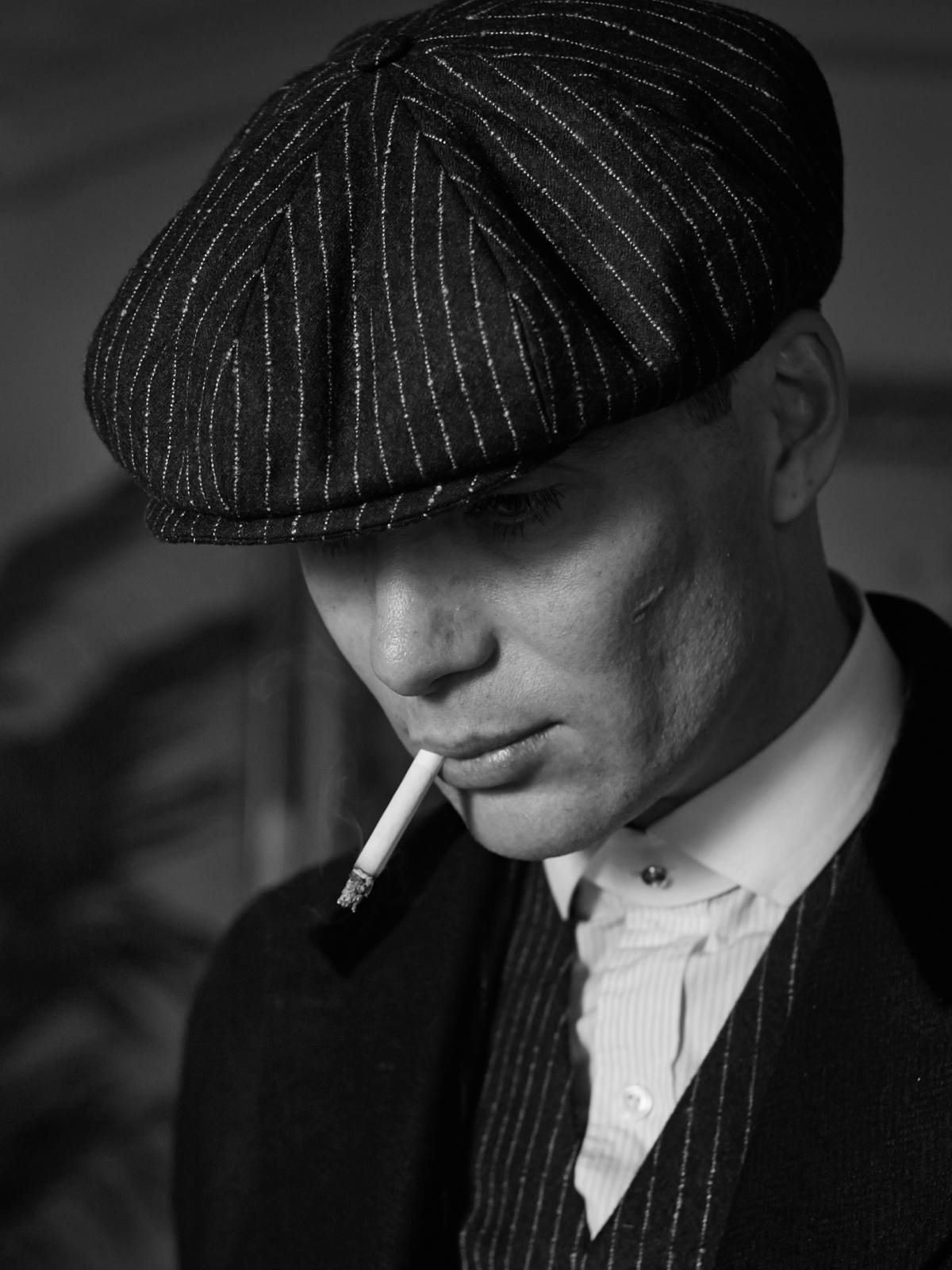 Tommy Shelby close-up in pinstripe cap and suit - quiet power, tailored heritage
