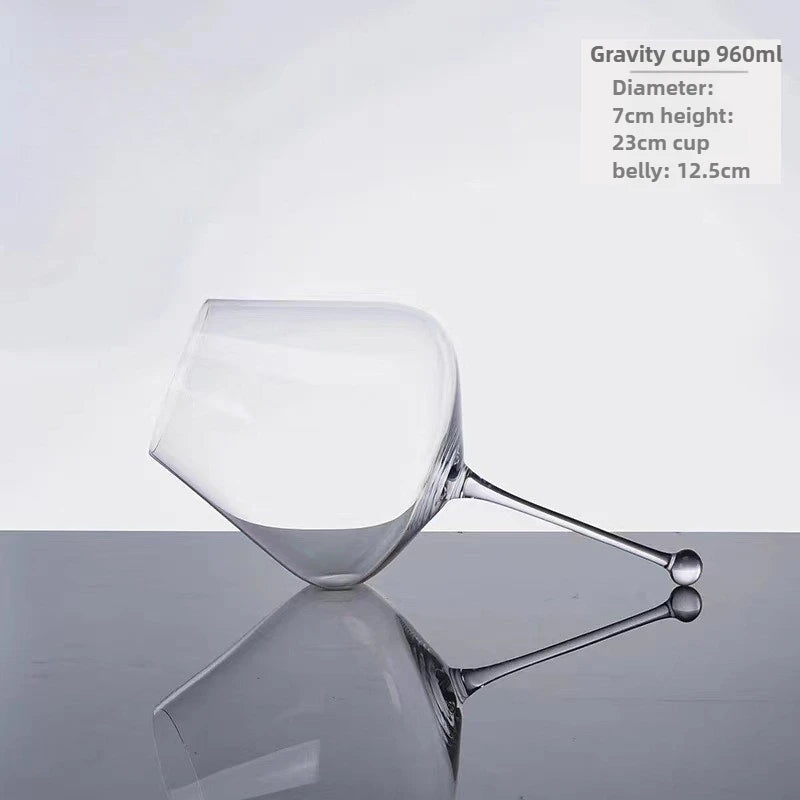 modern gravity wine glass on wooden table catching warm light
