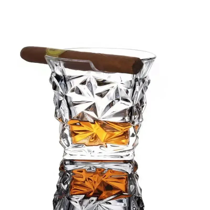 Hand holding whiskey and cigar glass during poker night