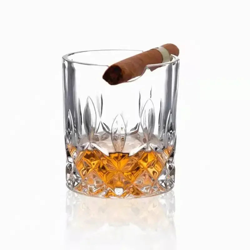 Hand holding whiskey and cigar glass during poker night