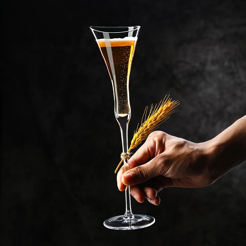 pair of tulip champagne goblets with golden sparkling wine on bar counter